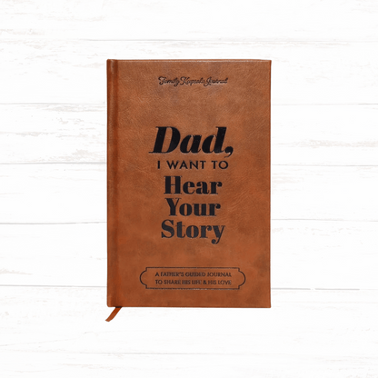 Brown leather journal with 'Dad, I Want to Hear Your Story' text on a white wooden background