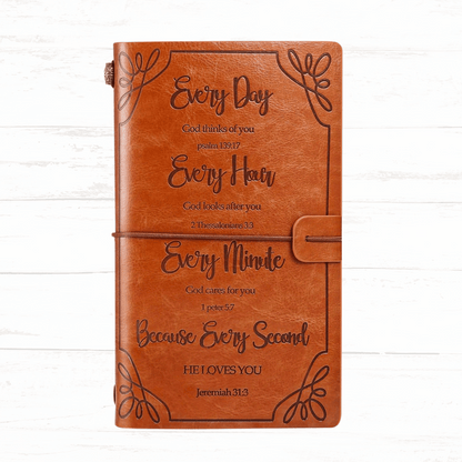 Brown leather notebook with engraved text on a white wooden background